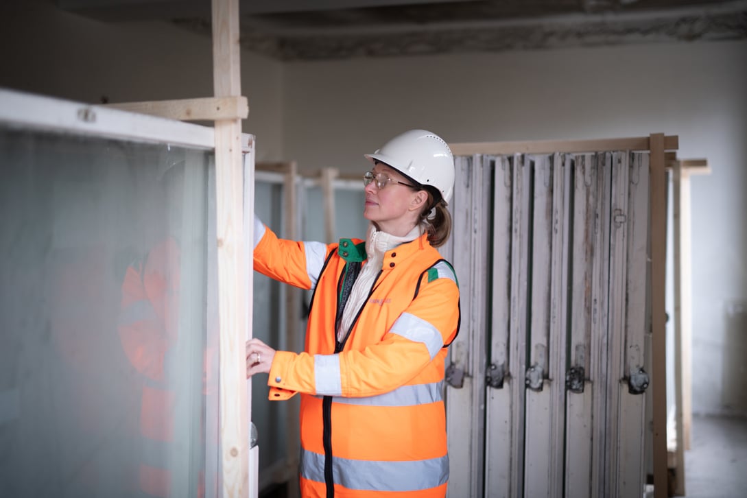 En kvinna fr&aring;n Ragn-Sells inspekterar f&ouml;nster som ska &aring;tervinnas