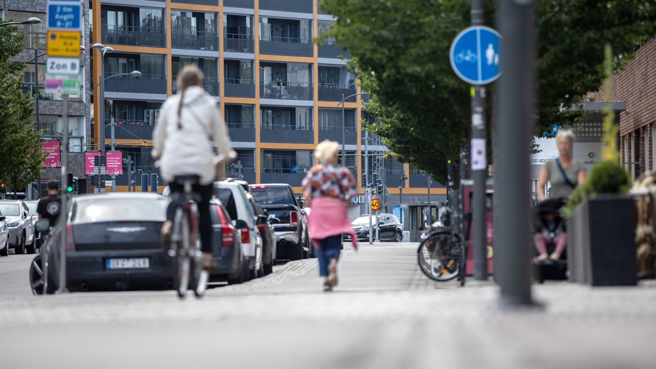 Människor i stad cyklar och går