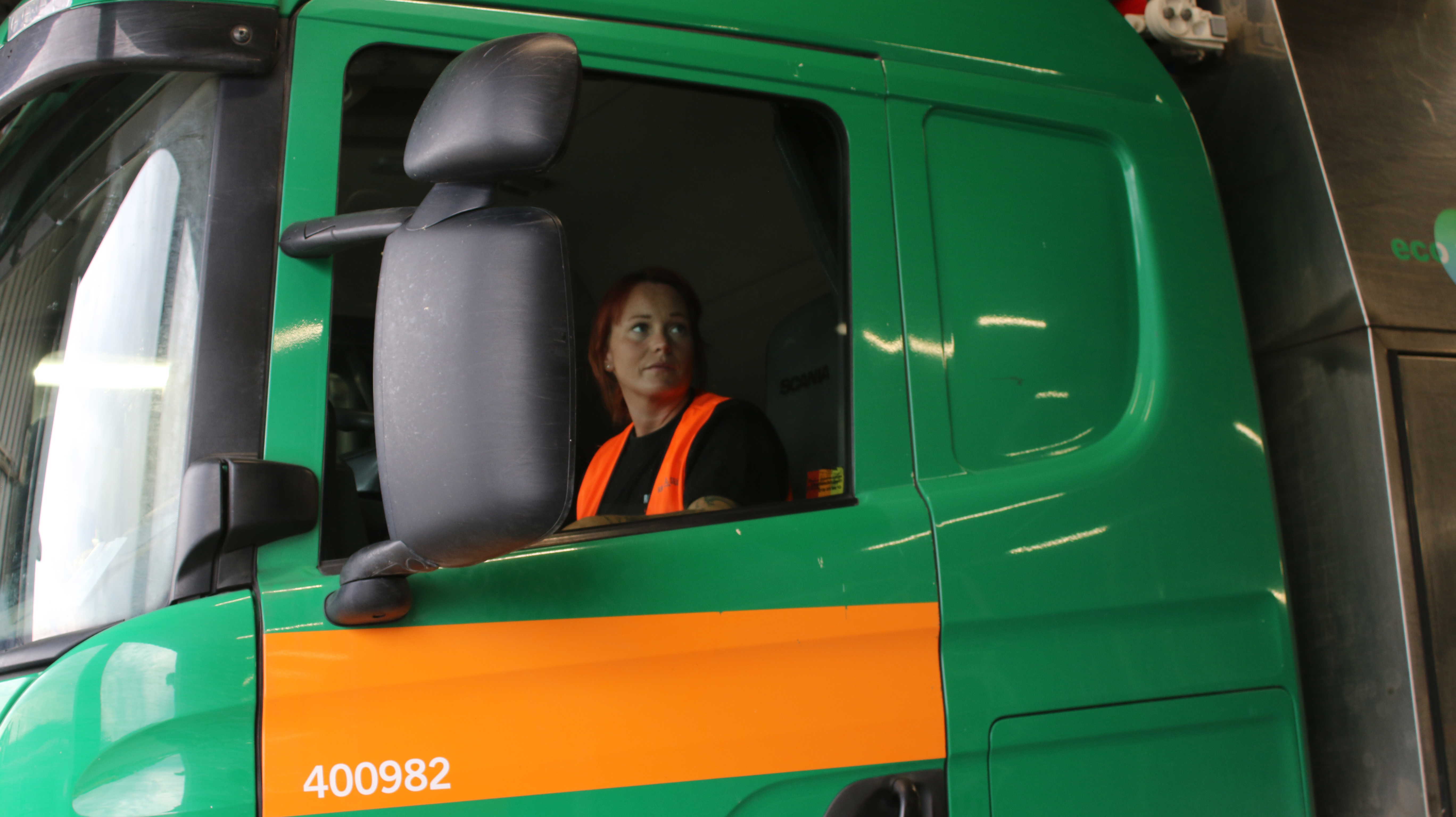 En kvinnlig chaufför sitter i en av Ragn-Sells fordon