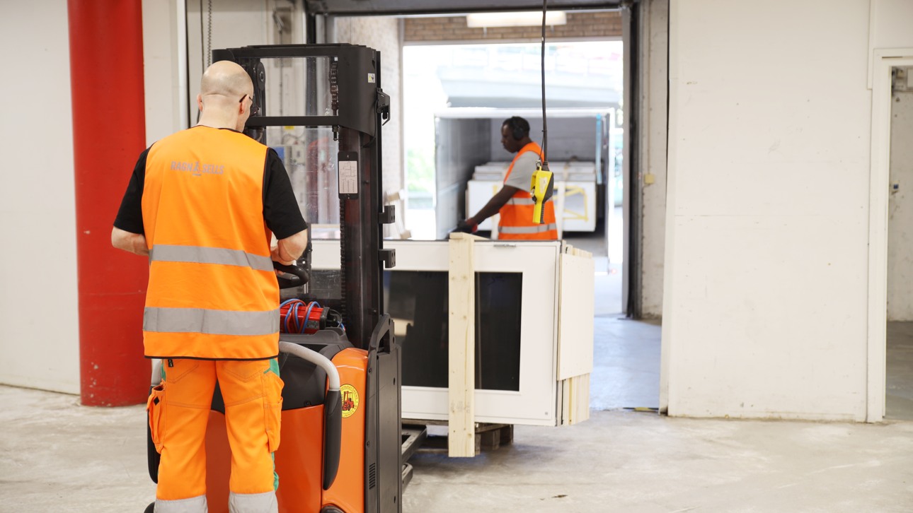En Ragn-Sells kollega fraktar fönster på en gaffeltruck i lokal för återbruk