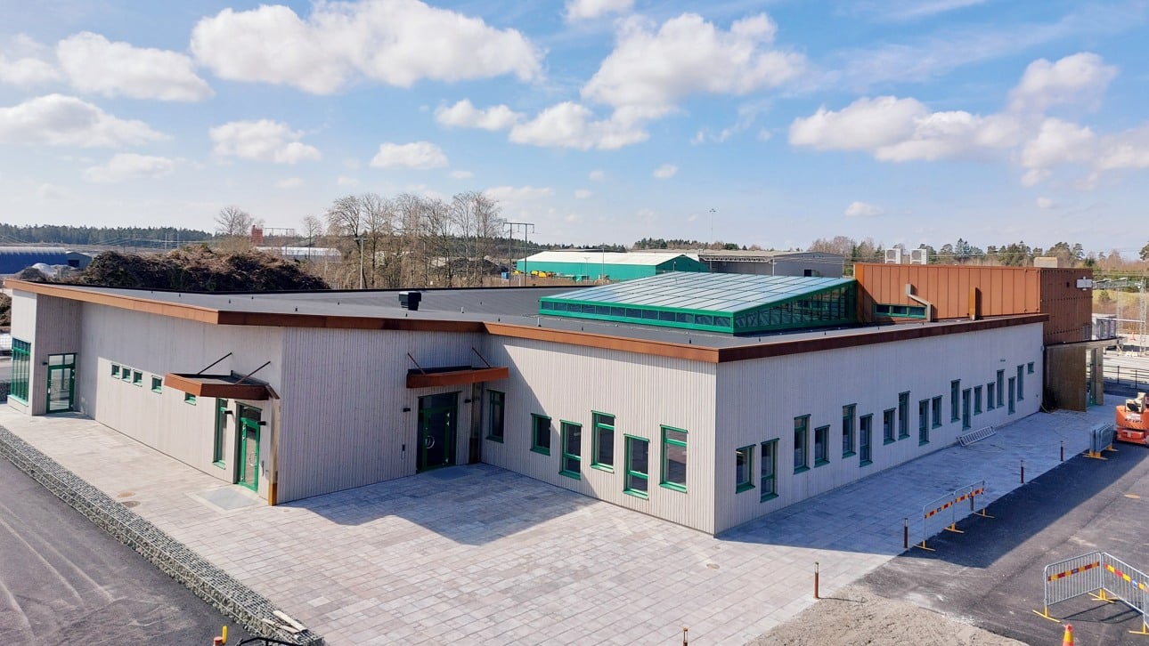 En modern kontorsbyggnad i vitt med gröna fönster