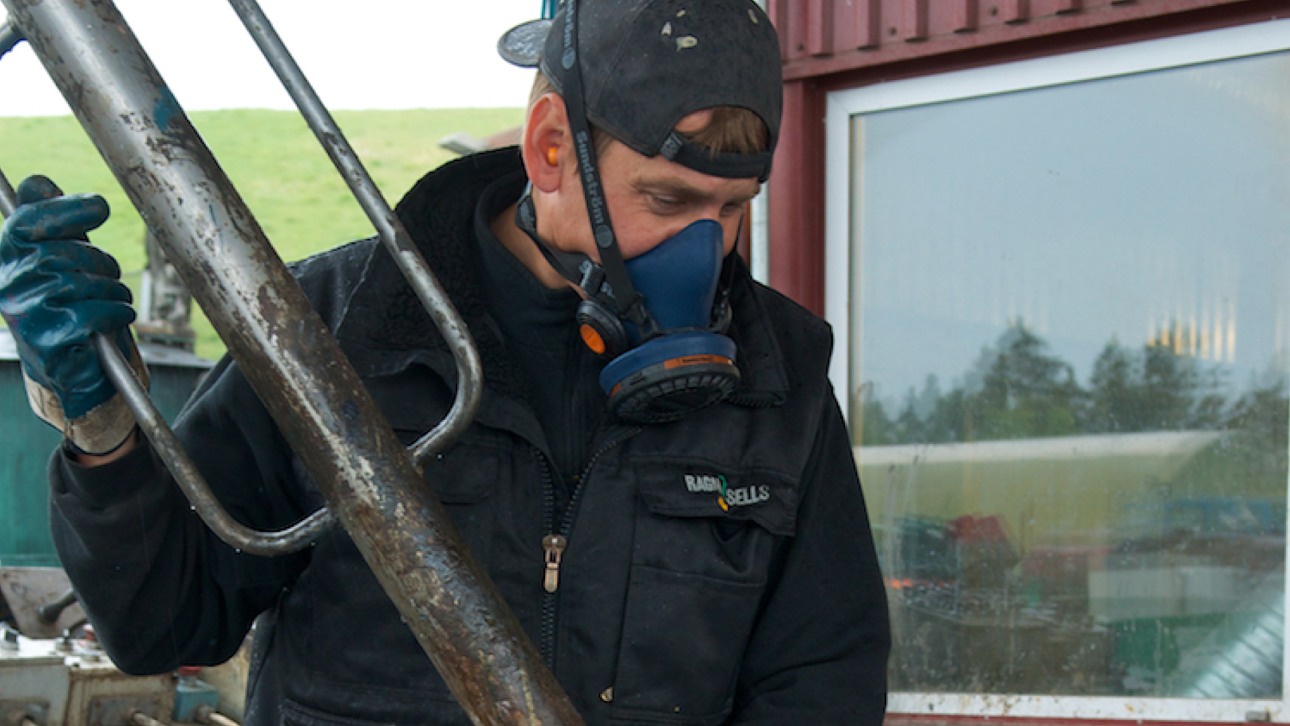 Man på Ragn-Sells som hanterar farligt avfall med mask över ansiktet