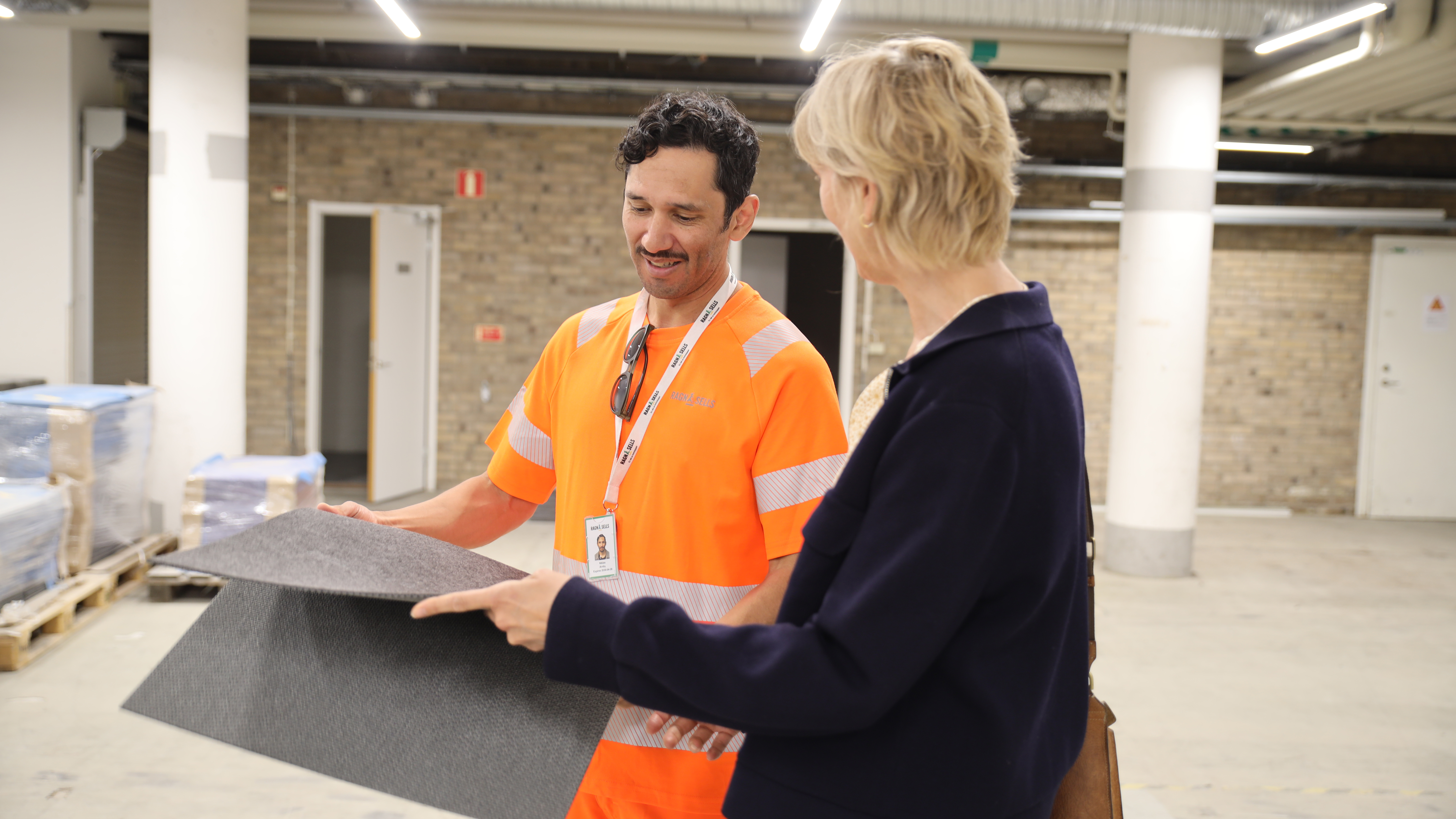 Ragn-Sells och en kund inspekterar mattbitar i Reboost återbrukshubben
